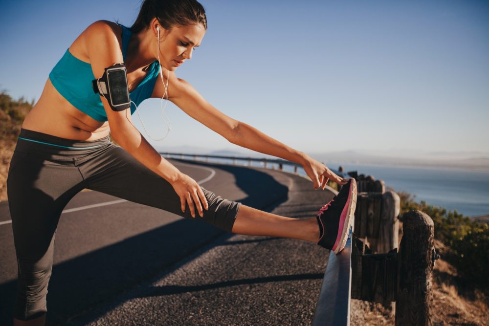 Female Runner Stretching Achilles Tendon Before Running